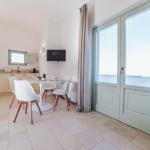 Essbereich mit Küchenzeile und Balkontür. Weiße Stühle um runden Tisch.