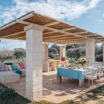 Terrasse mit Pavillon, Esstisch und Sitzbank unter Dach