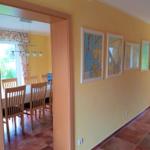 Flur mit Wandkarten und Blick in Esszimmer mit Tisch und Stühlen.