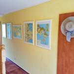 Flur mit gelber Wand, Karten und Strohhut an Tür