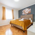 Schlafzimmer mit Bett, Wandbild und Holzboden