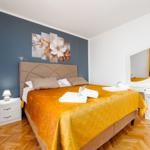 Schlafzimmer mit Bett, Schminktisch und Wandbild.