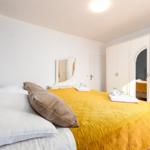 Schlafzimmer mit Bett, Kleiderschrank und Spiegel