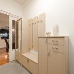 Eingangsbereich mit Garderobe und Schuhschrank. Durchgang in Wohnbereich mit Kamin und Fernseher.