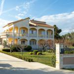 Zweistöckiges Haus mit Balkonen und gepflegtem Garten.