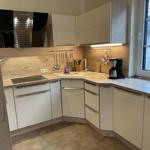 Küche mit Holzoptik, Spüle, Kaffeemaschine und Fenster.