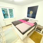 Schlafzimmer mit Doppelbett, Fenster und Wandbild.