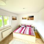 Schlafzimmer mit Bett, Fenster und Wandbildern