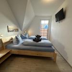 Schlafzimmer mit Doppelbett, Fernseher und Fenster