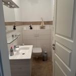 Badezimmer mit Waschbecken, Toilette und Spiegel