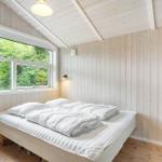 Bedroom with wooden walls, bed, and window to the forest.