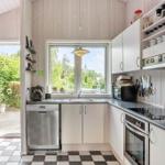 Kitchen with white cabinets, window and black-and-white floor