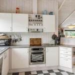 Kitchen with white cabinets, stainless steel appliances, and black-and-white floor tiles.