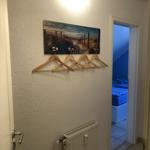 Flur mit Kleiderhaken und Wandbild, Tür zum Schlafzimmer