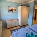 Zwei Betten, Kleiderschrank und Schrank mit Bild an der Wand.