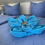 Blauer Bettbezug mit blauen Kissen und einem blauen Handtuch in Blumendekoration.