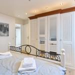 Schlafzimmer mit Bett, Kleiderschrank und Wandbild.