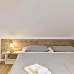 Schlafzimmer mit Doppelbett, Holzpaneelen und Nachttisch mit Lampe.