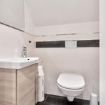 Badezimmer mit Waschbecken, Toilette und Spiegelschrank.