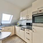 Küche mit Schränken, Arbeitsfläche und Fenster