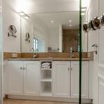 Badezimmer mit Waschbecken, Spiegel und Dusche