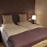 Schlafzimmer mit Doppelbett, zwei Nachttischen und Lampen.