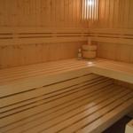 Sauna mit Holzbänken, Eimer und Flasche