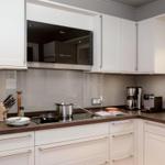 Küche mit weißen Schränken, dunkler Arbeitsplatte und integriertem Herd.