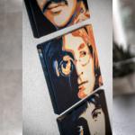 Holzskulpturen, Wandbilder und eine Teekanne sind im Raum zu sehen.