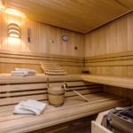 Sauna mit Holzbank, Handtuch und Eimer