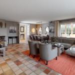 Wohn- und Essbereich mit Kamin, Sitzgruppe und Terrakottboden.