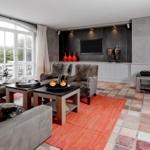 Wohnzimmer mit Sitzgruppe, Flachbildschirm und Terrassentür.