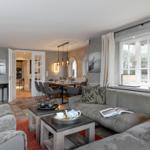 Wohn- und Essbereich mit Sofa, Tisch und Blick auf Garten.