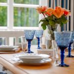 Esszimmertisch mit blauen Gläsern und Rosenstrauß
