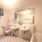 Badezimmer mit zwei Waschbecken, Badewanne und Toilette.