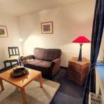 Ein Wohnzimmer mit Sofa, Stuhl, Tisch und Lampe.