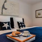 Schlafzimmer mit Bett, Kissen und Frühstückstablett.