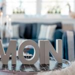 MOIN-Schriftzug auf Tisch, Sofa und Fenster im Hintergrund.