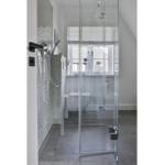 Duschbereich mit Glaswand, Toilette und Fenster im Badezimmer.