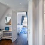 Durchgang zu Schlafzimmer mit blauem Teppich und Fenster