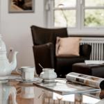 A living room with table, coffee cup, and magazine.