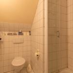 Badezimmer mit Dusche, Toilette und Waschbecken.