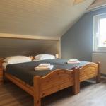 Schlafzimmer mit Holzbett, Fenster und Blumen