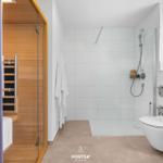 Dusche, Toilette und Sauna in einem Raum.