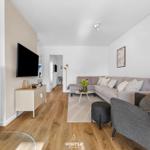 Wohnzimmer mit Sofa, Kamin und Fernseher.