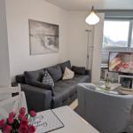 Wohnzimmer mit Sofa, Fernseher und Blick auf die Straße.