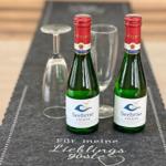 Zwei Seebriese-Flaschen und Gläser auf einem Tisch mit Aufschrift für Gäste.