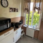 Küche mit Mikrowelle, Kaffeemaschine und Fenster mit Blick auf Grün.