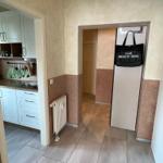 Flur mit Küchenbereich und Garderobe mit Strandtasche.