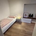 Ein Schlafzimmer mit einem Bett, Nachttisch und Holzboden.